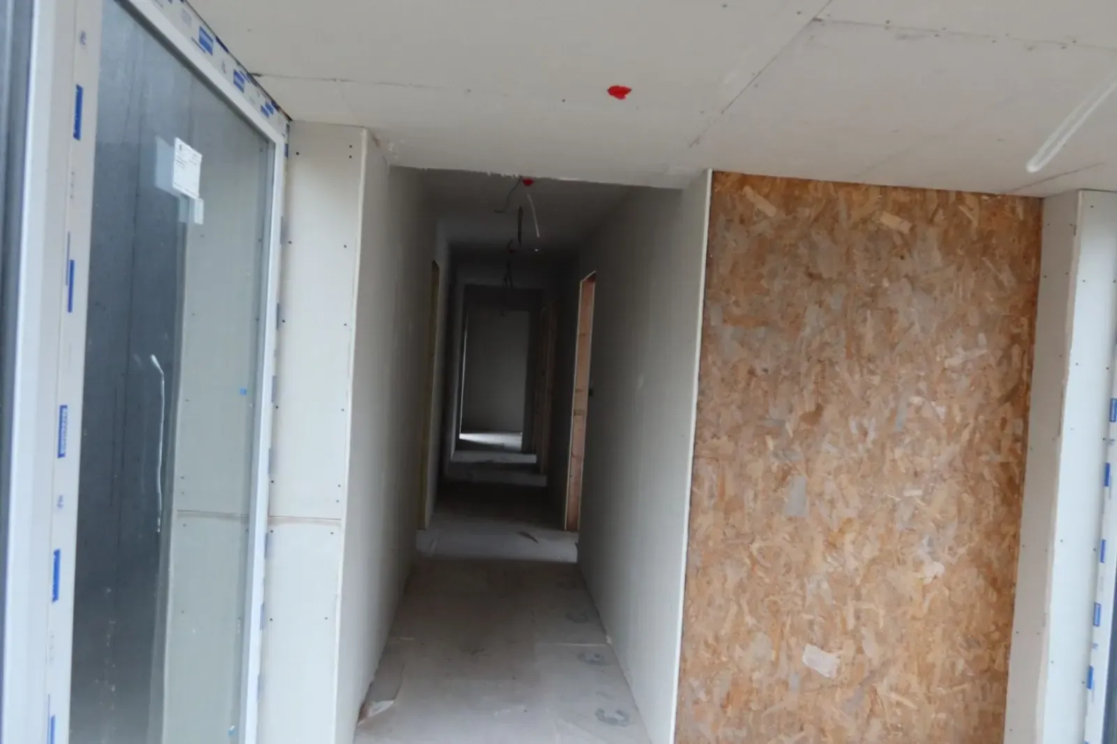 Interior hallway undergoing renovation with plasterboard installed for internal wall insulation