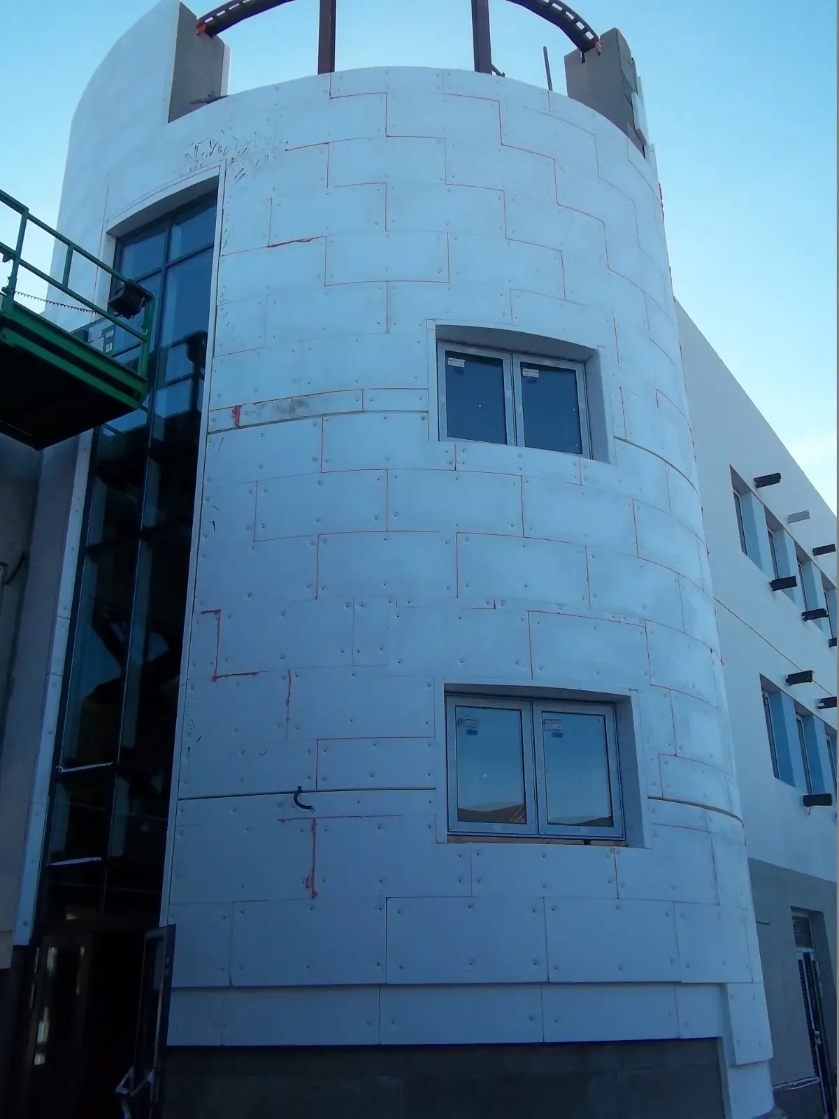 External wall insulation panels fitted to a curved building facade by Global Energy Insulation experts.