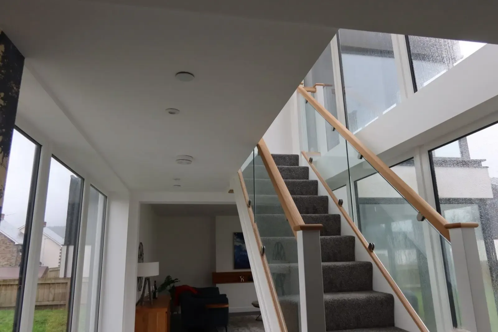 A modern interior featuring a glass staircase, highlighting a warm and well-insulated home, services provided by Global Energy Insulation.
