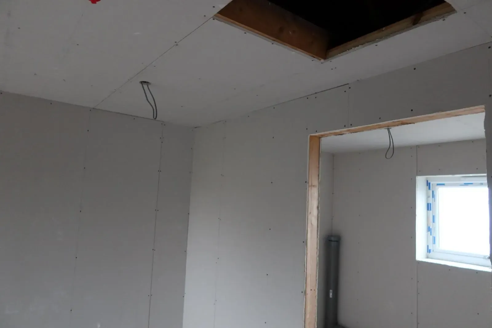 Newly installed plasterboard on interior walls and ceiling during an internal wall insulation project